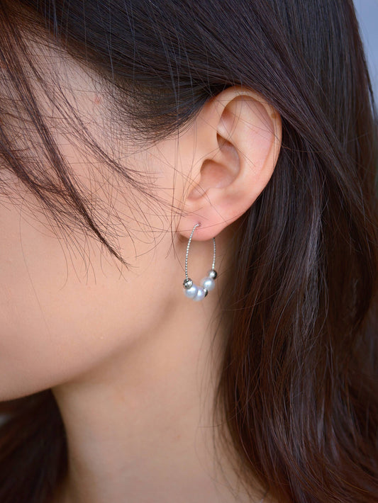 Model wearing Cyrene Halo Pearl Hoop Earring, lightweight silver hoop with aurora pearls peeking through hair