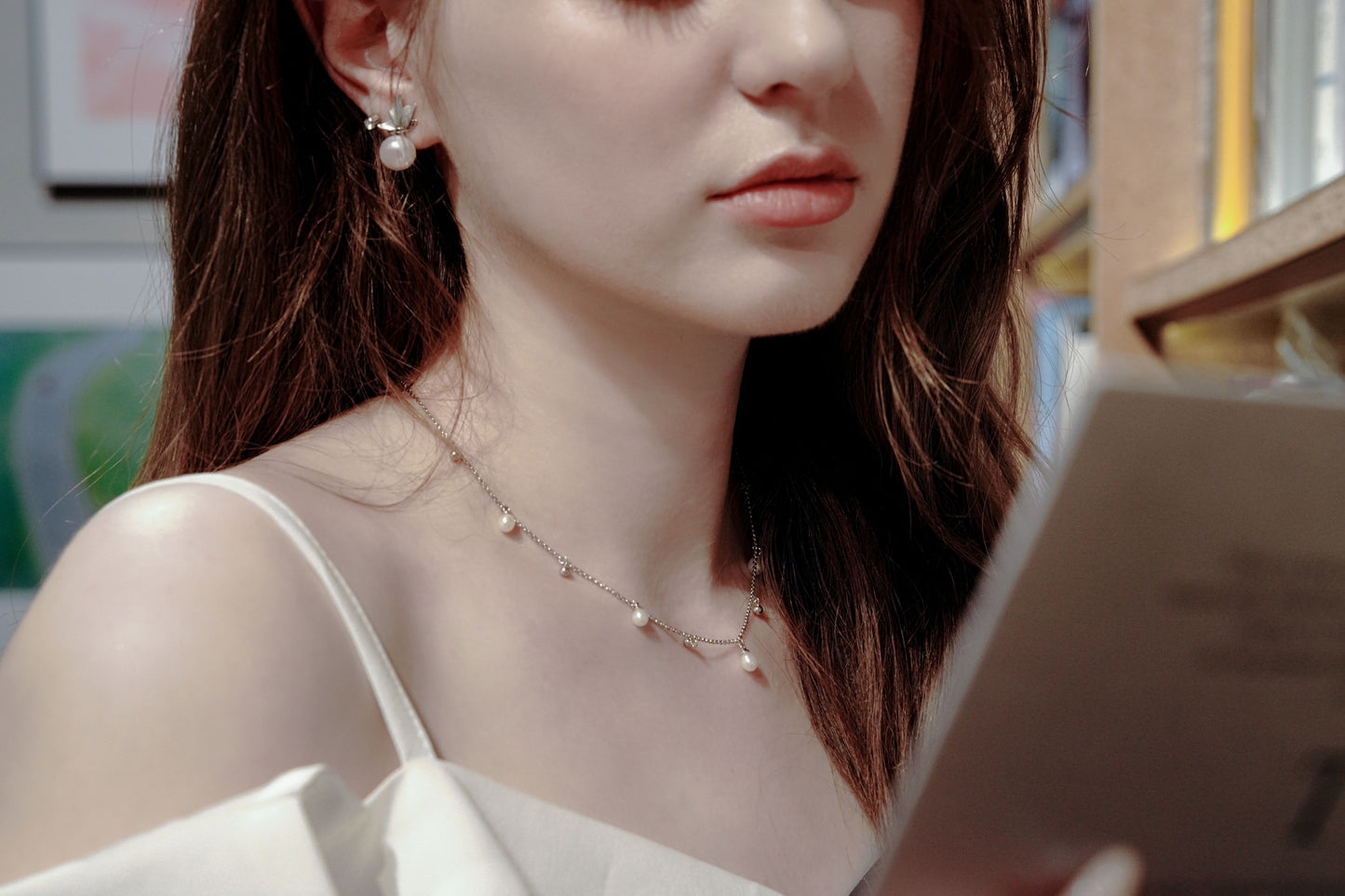 Close-up on the collarbone showing Cyrene's adjustable 40cm silver necklace, highlighting the beautiful spacing of the movable freshwater pearls