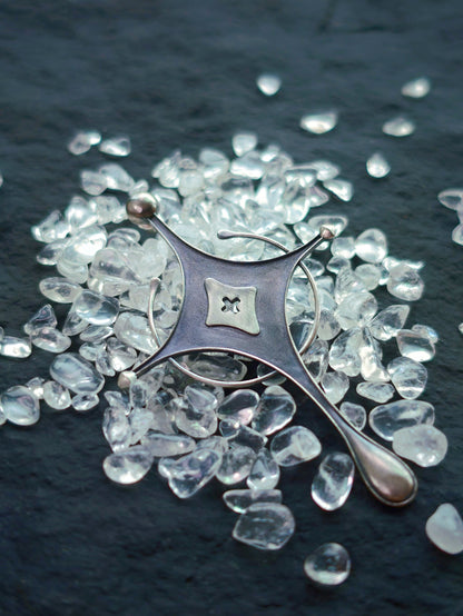 Cyrene Axiom Cross 925 silver earring angled flat lay, asymmetric indie jewelry handcrafted statement piece