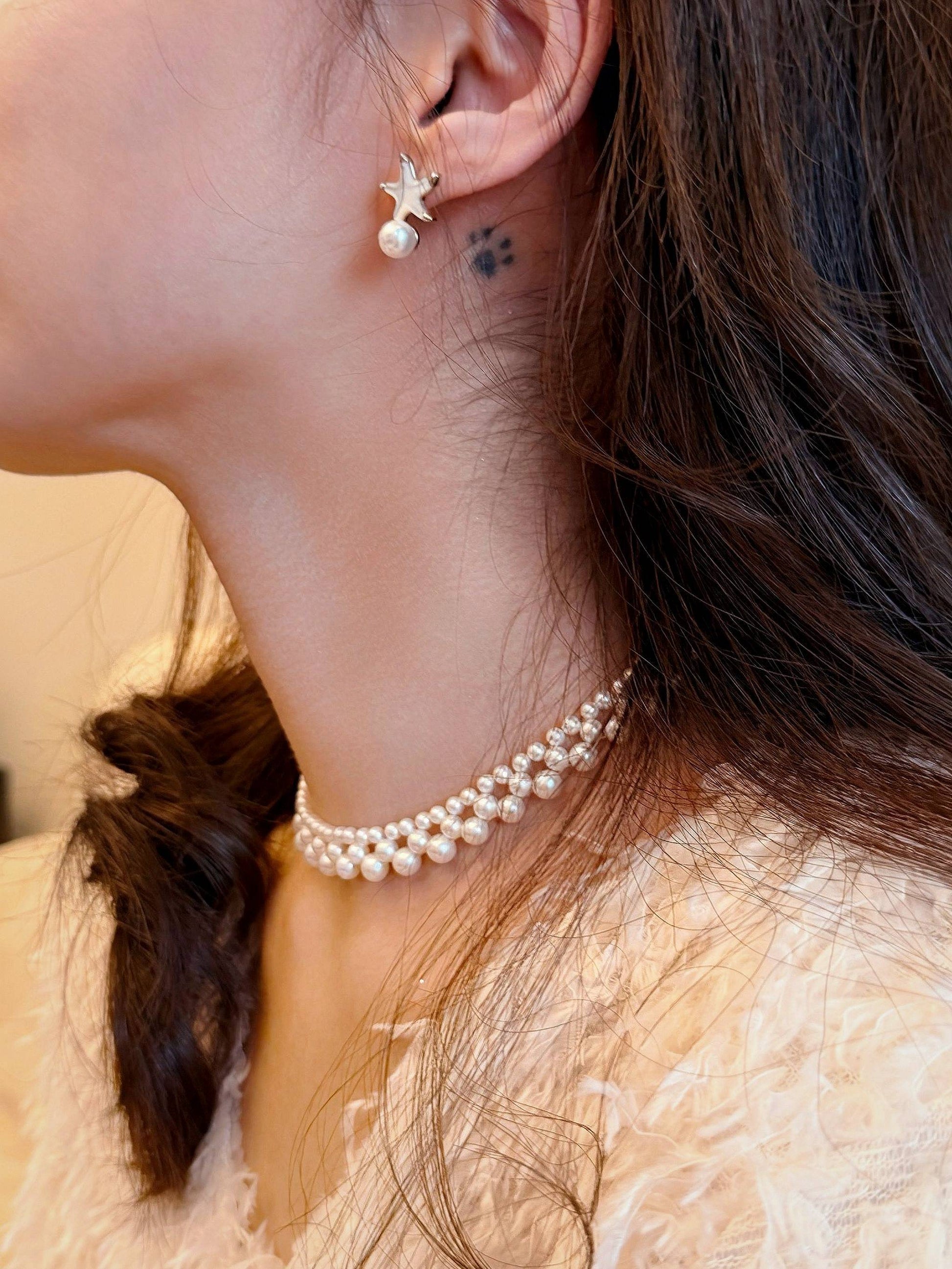 Effortlessly chic summer styling featuring Cyrene's mother-of-pearl starfish earrings, perfect for pairing with vibrant resort dresses