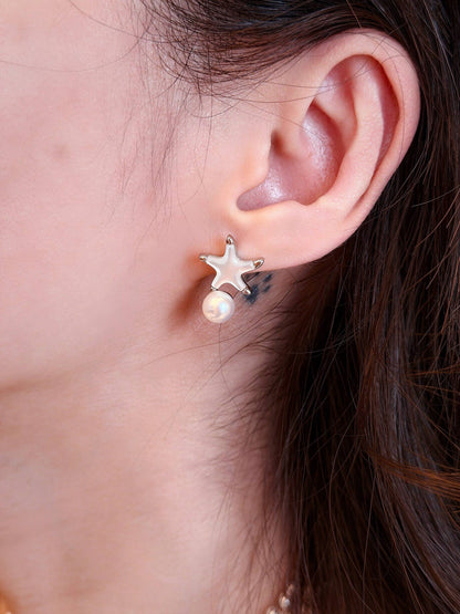 Close-up on a model wearing Cyrene's beach aesthetic starfish earrings, featuring hand-selected pearls with options for larger custom sizes