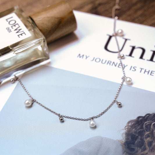 Cyrene's highly customizable freshwater pearl drop and silver bead chain necklace, beautifully displayed in an aesthetic lifestyle setting.