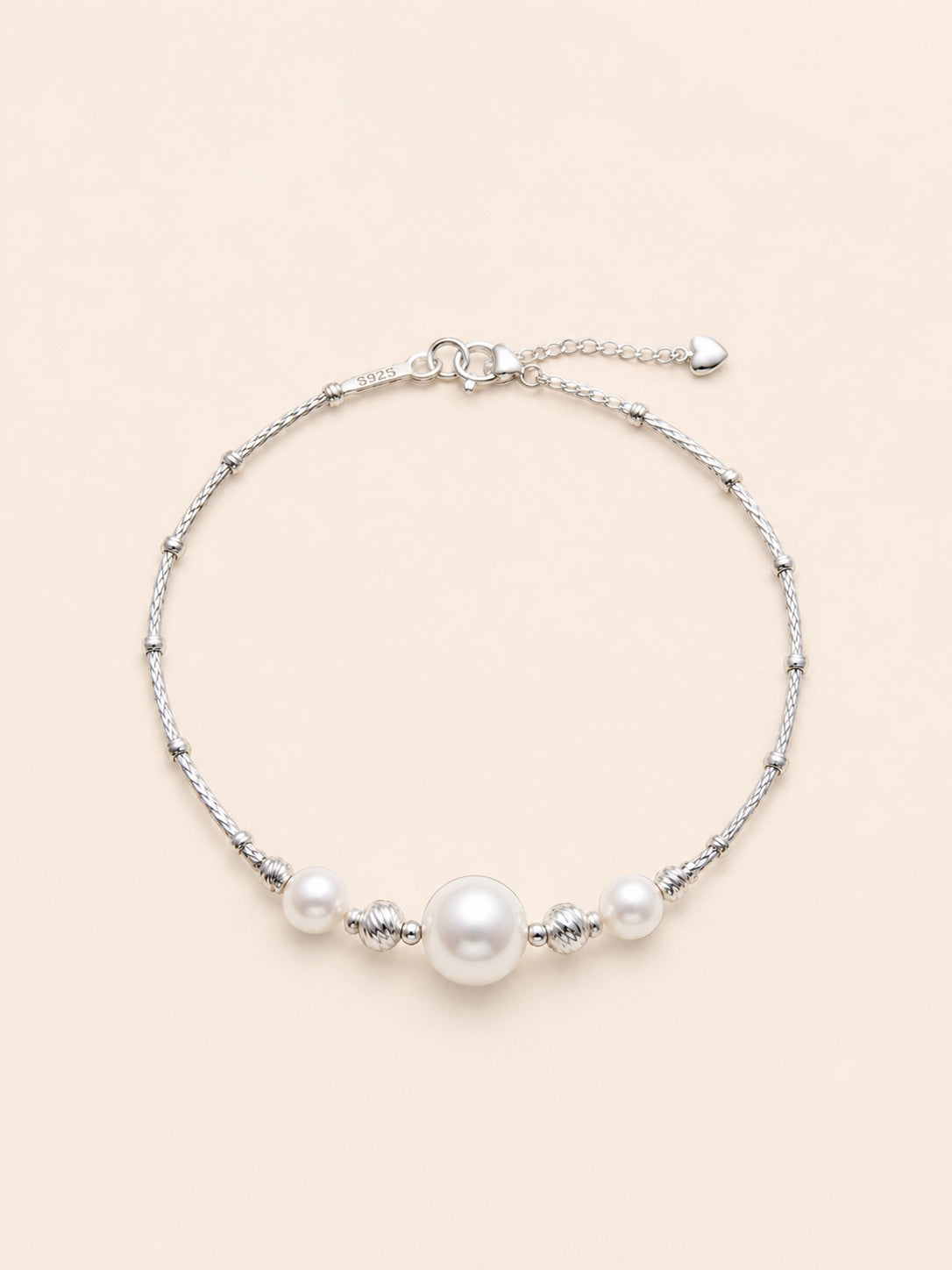 Moirae Pearl Bar Bracelet with three freshwater pearls and textured 925 sterling silver tube links on a soft ivory background