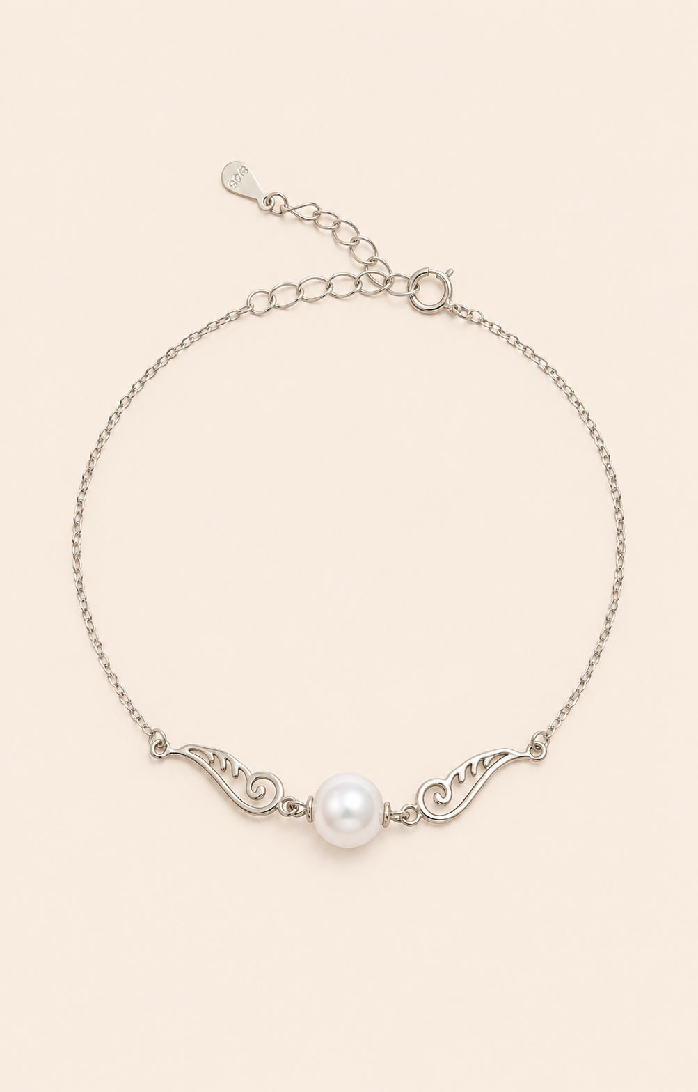 Pinion Pearl Bracelet with a freshwater pearl and delicate 925 sterling silver wing details on a soft ivory background