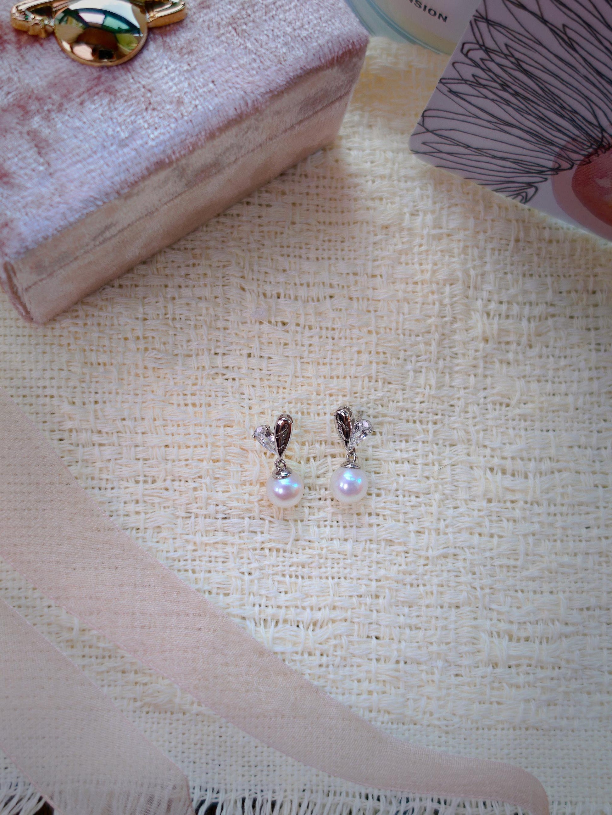 Cyrene by Elsie Demi Pearl Earrings flat lay showing 925 silver and CZ heart studs with 7-8mm aurora freshwater pearl drops