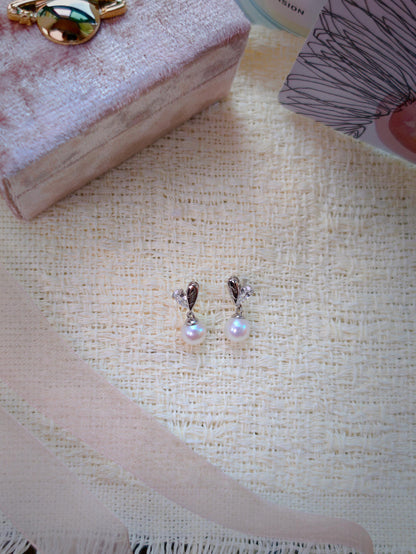 Cyrene by Elsie Demi Pearl Earrings flat lay showing 925 silver and CZ heart studs with 7-8mm aurora freshwater pearl drops