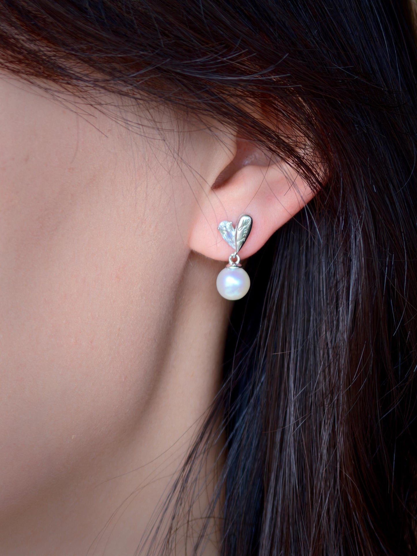 Model wearing Cyrene by Elsie's Demi Pearl Earrings with aurora freshwater pearl drop and CZ heart stud
