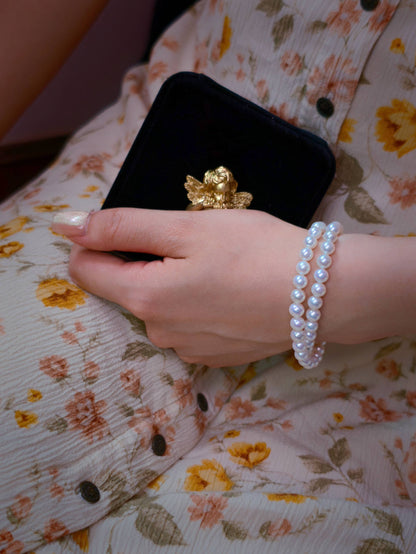 Model wearing Cyrene by Elsie's 6-7mm double strand pearl bracelet alongside a velvet jewelry box