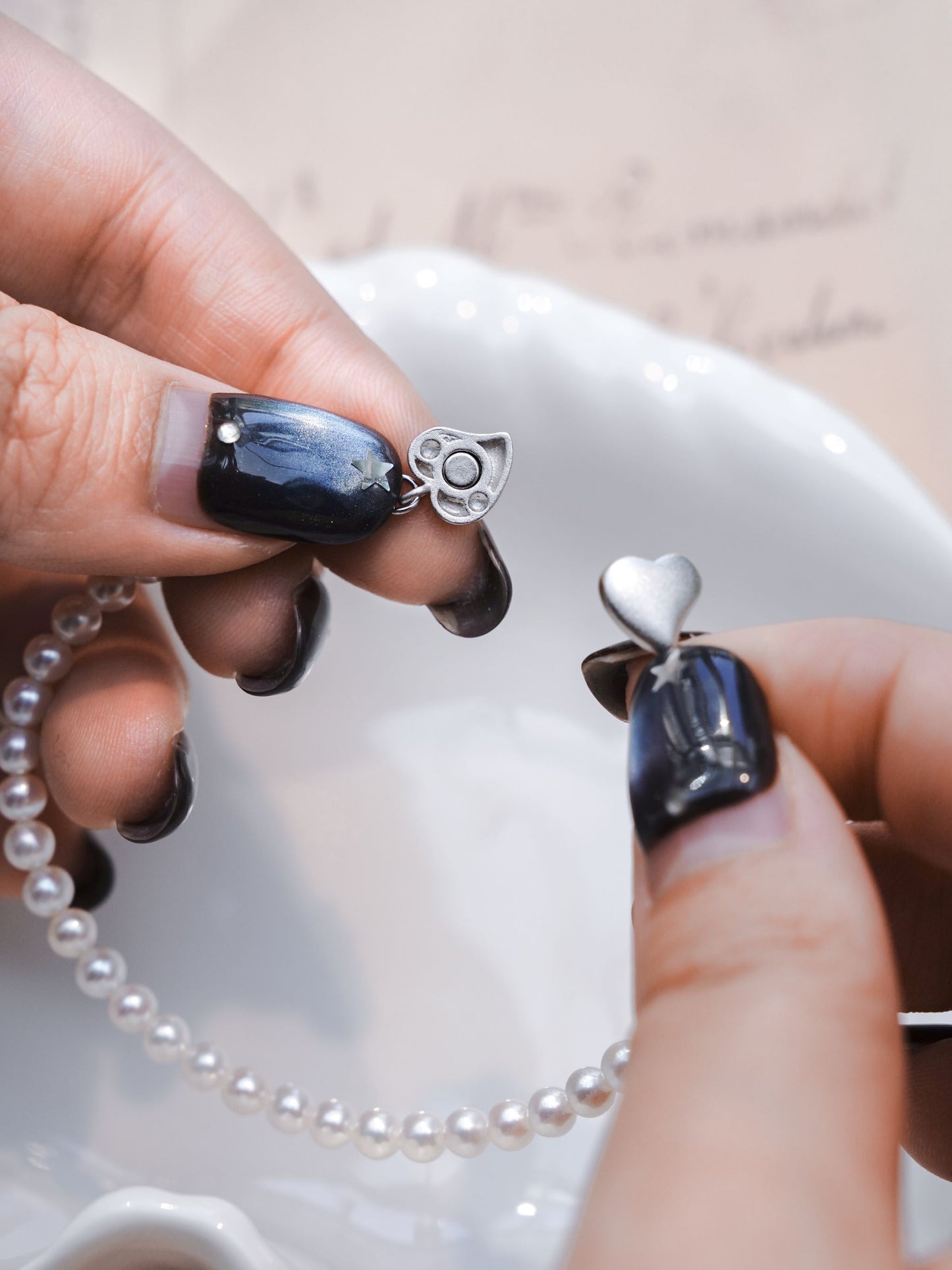 Demonstration of the easy-to-wear, top-to-bottom secure magnetic heart clasp on Cyrene's elegant seed pearl bracelet.