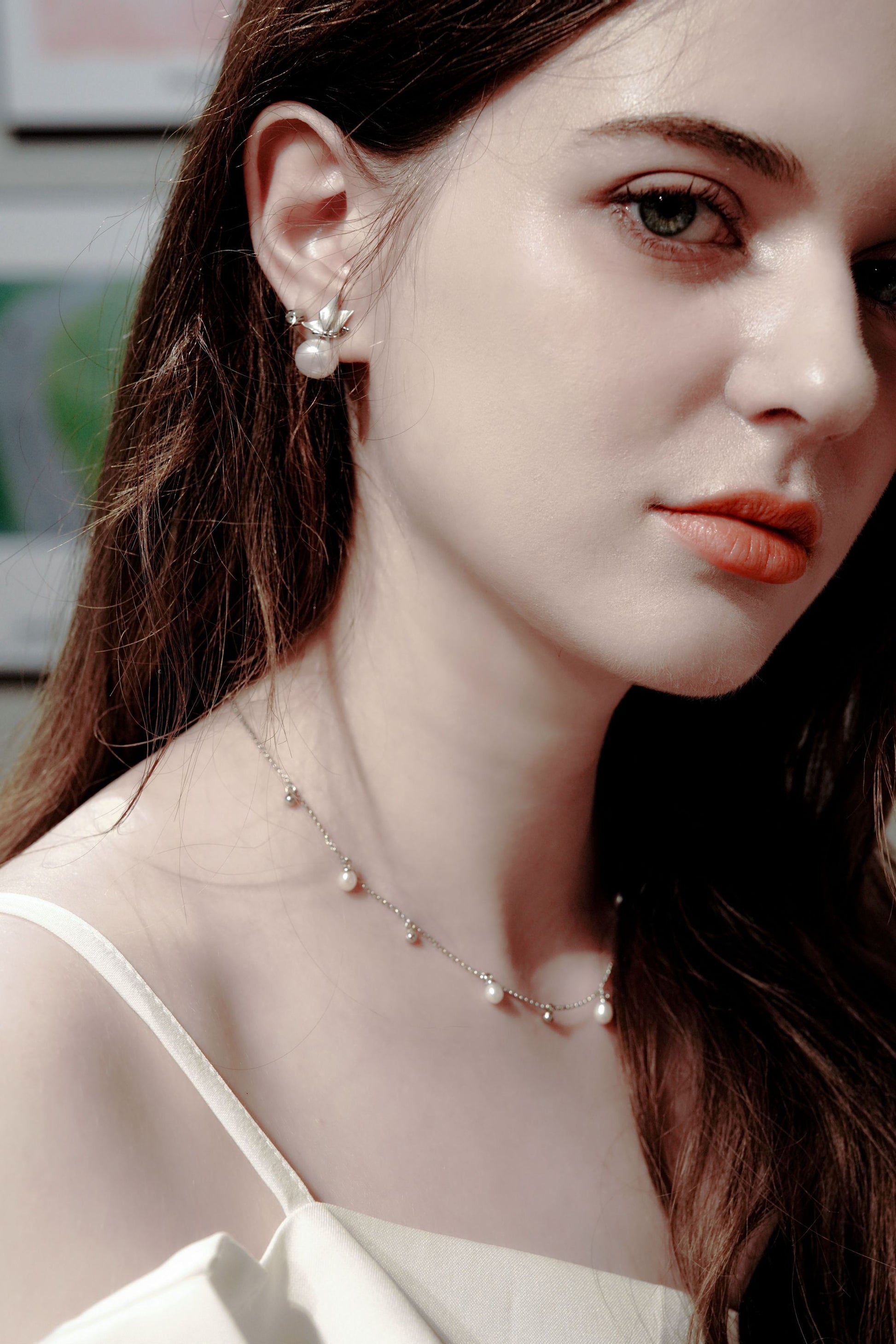 Sophisticated styling showcasing Cyrene's dynamic pearl station necklace perfectly paired with matching freshwater pearl earrings
