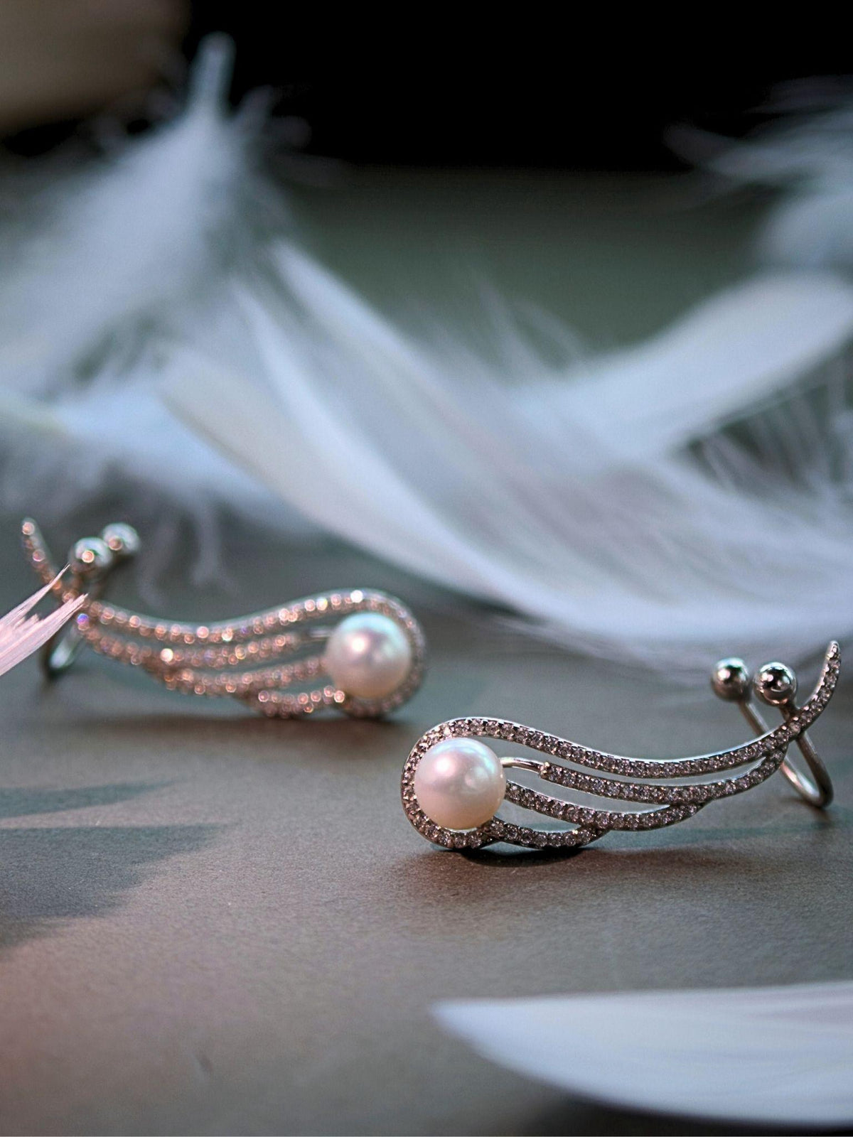 Featherrise Wing Pearl Ear Climber with freshwater pearls and pavé CZ styled with soft white feathers