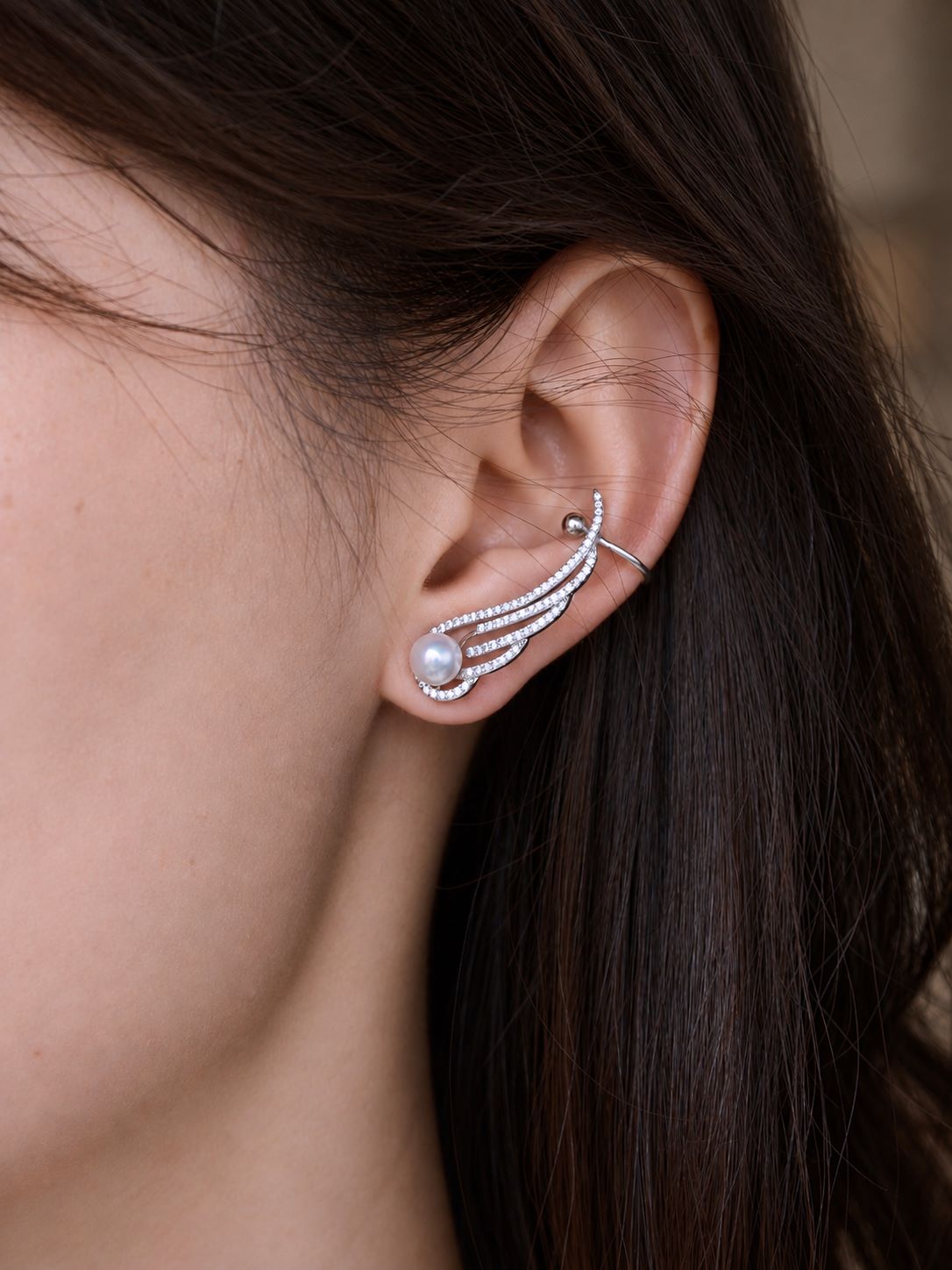 Side view of Cyrene Featherrise Wing earring on model, ear cuff climber with freshwater pearl and CZ wing, 3cm length