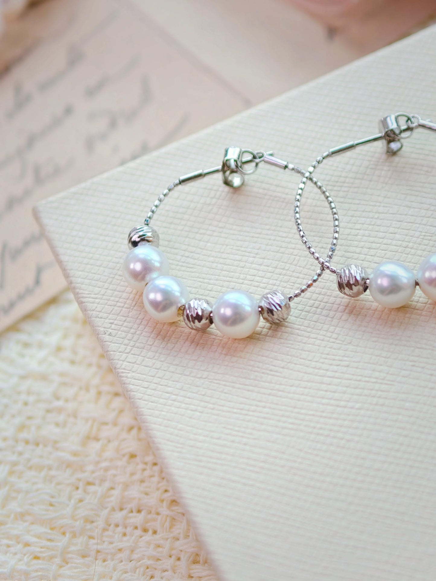 Cyrene Halo Pearl Hoop Earring detail showing silver wire hoop and pearl placement, angled close-up