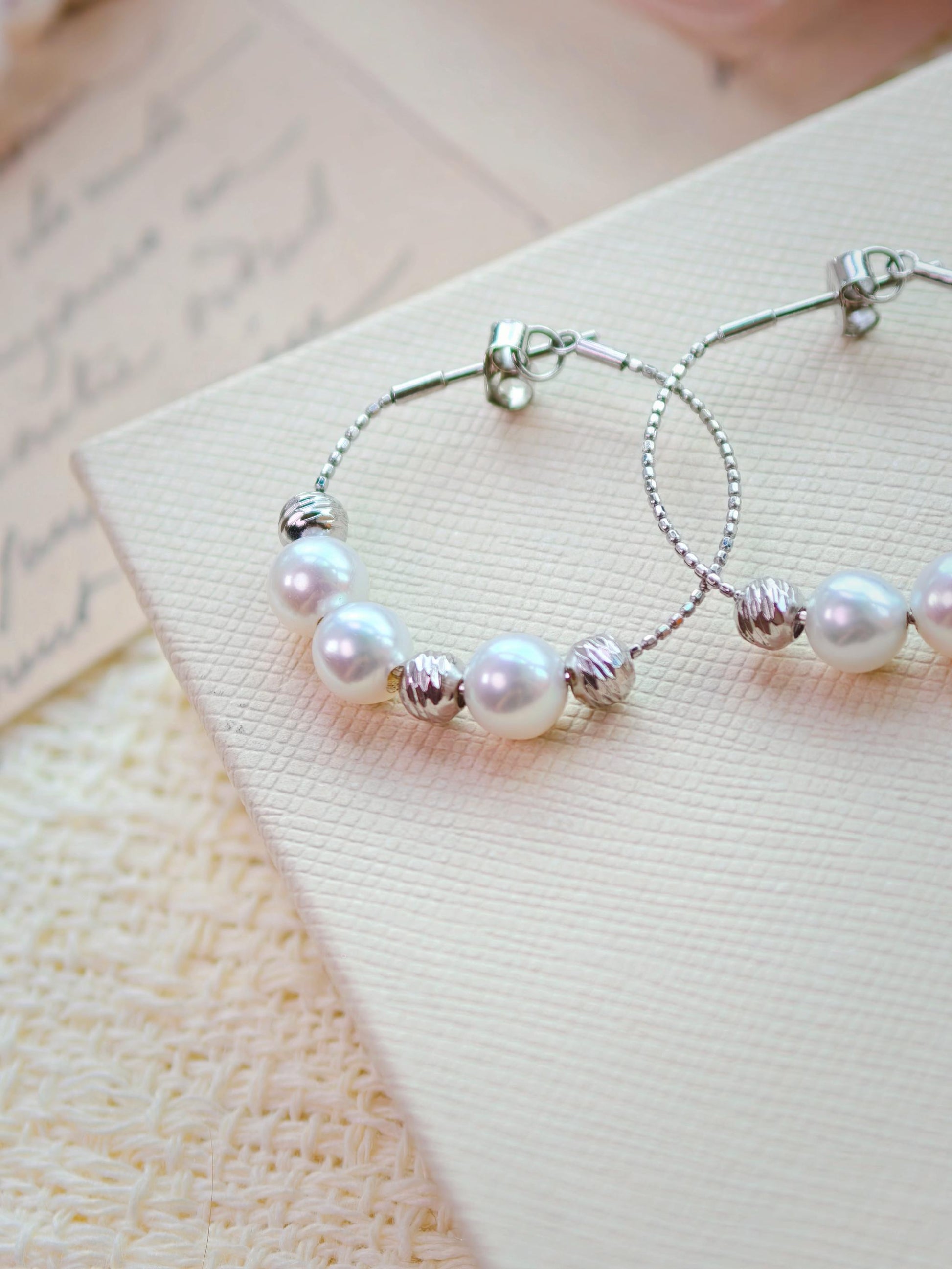 Cyrene Halo Pearl Hoop Earring detail showing silver wire hoop and pearl placement, angled close-up