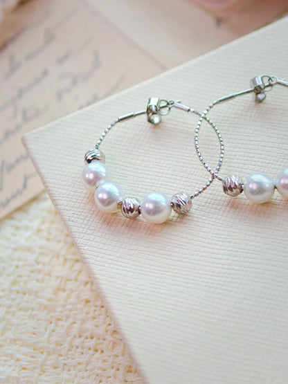 Cyrene Halo Pearl Hoop Earring detail showing silver wire hoop and pearl placement, angled close-up