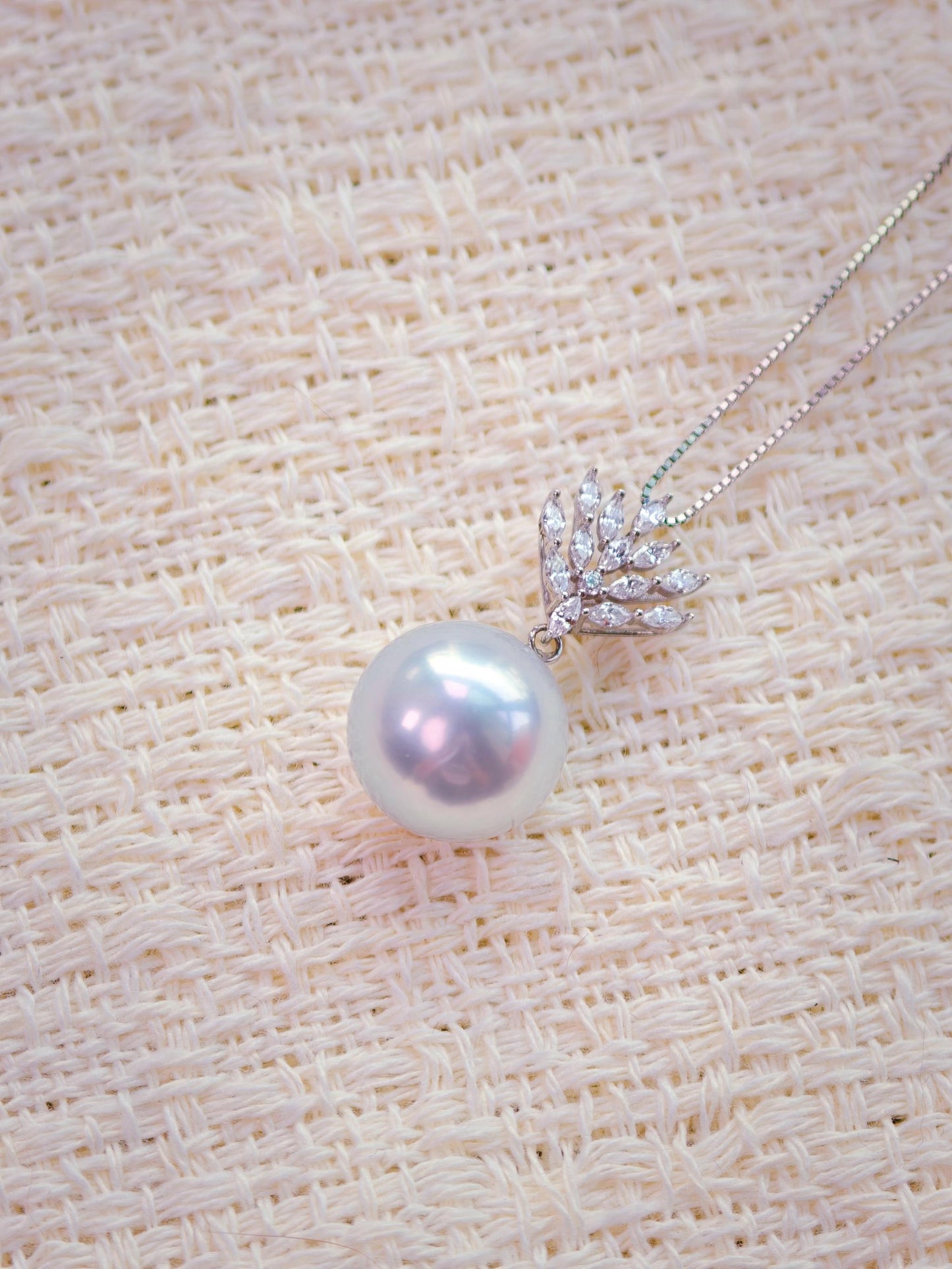 Cyrene Lone Drop Pearl Pendant close-up — 13.3mm round South Sea pearl with 18K white gold and CZ leaf setting