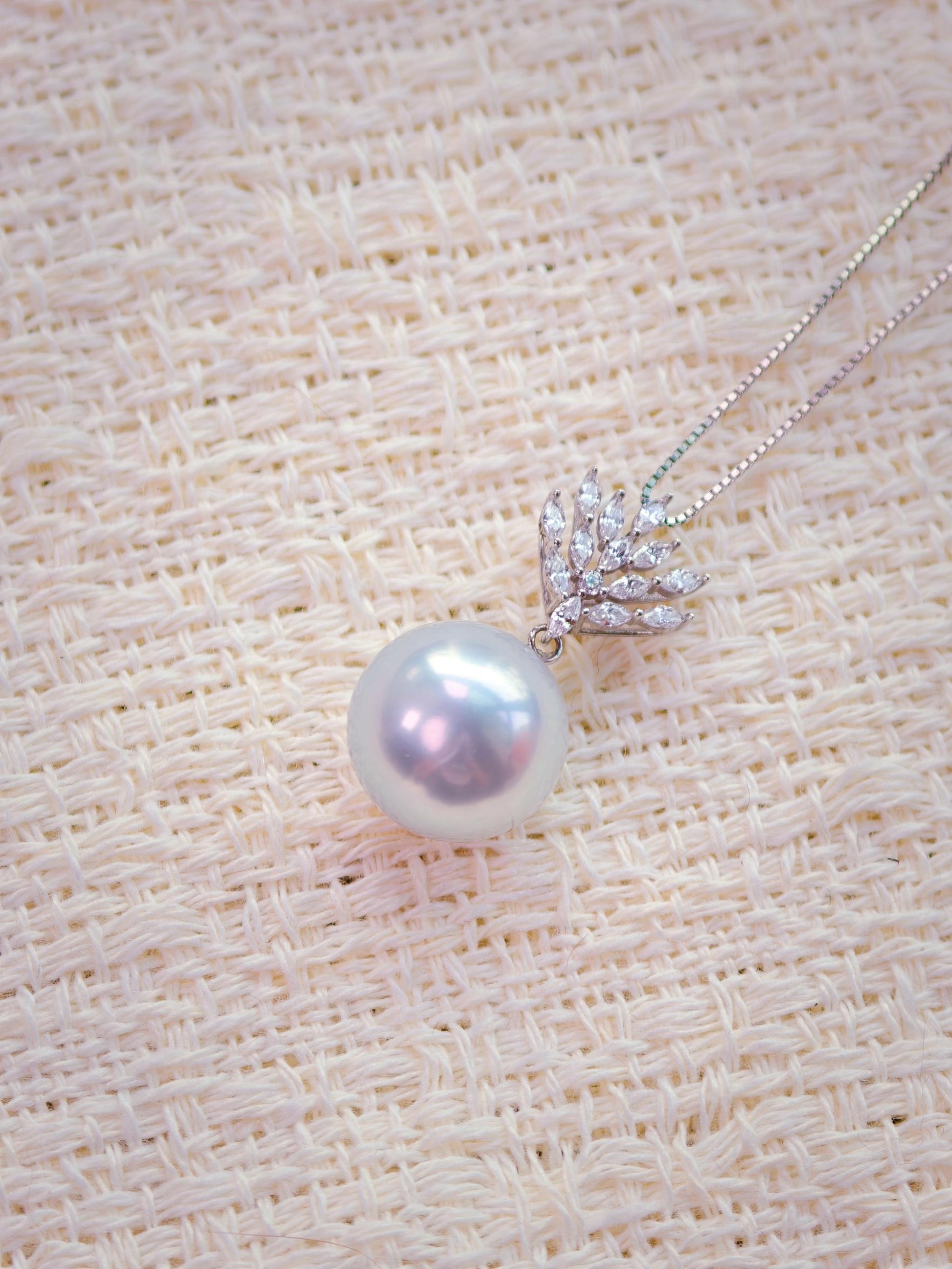 Cyrene Lone Drop Pearl Pendant close-up — 13.3mm round South Sea pearl with 18K white gold and CZ leaf setting