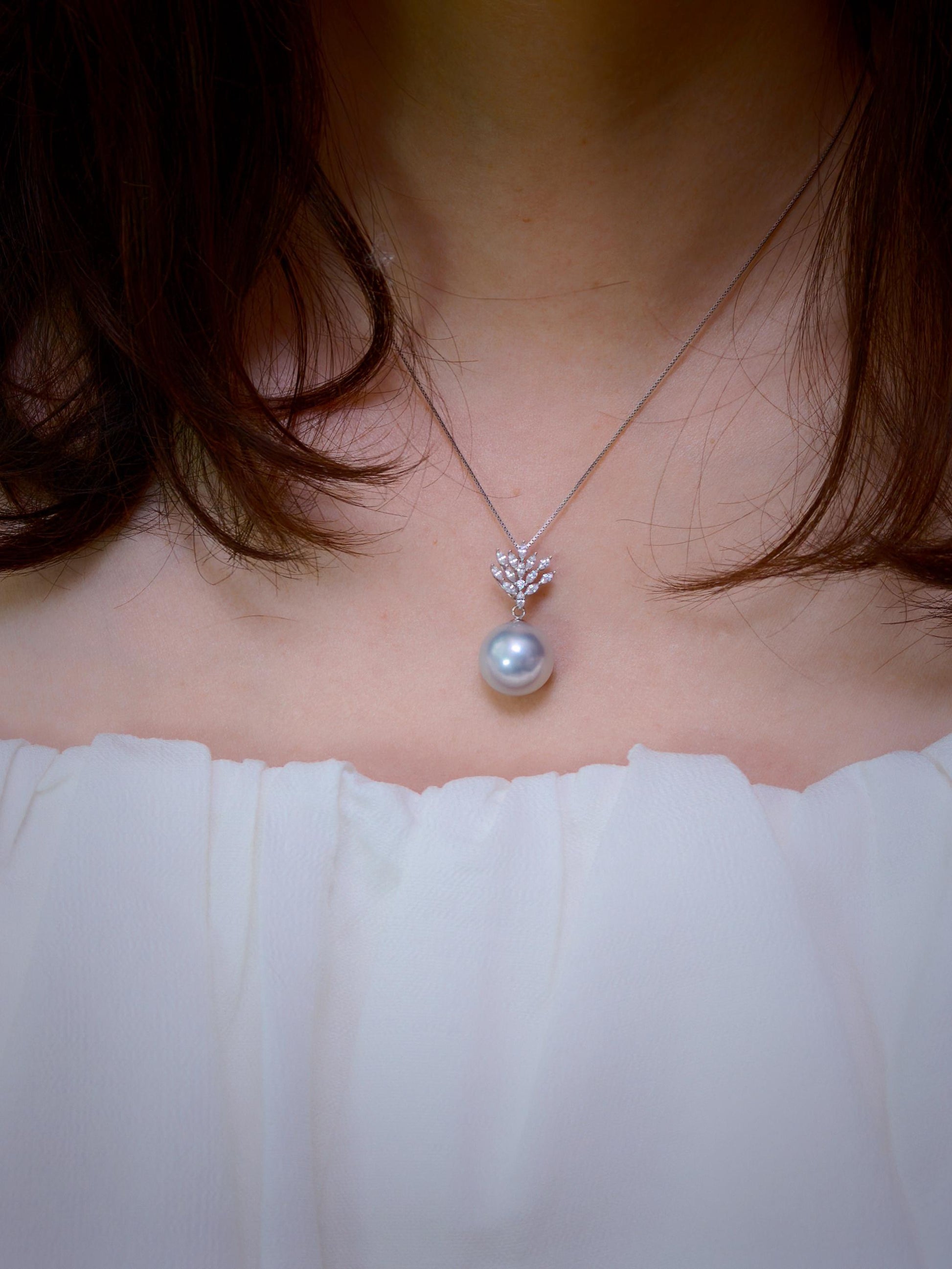 Cyrene Lone Drop Pearl Pendant worn close-up on neck — rare silver-blue South Sea pearl with 18K white gold CZ leaf pendant