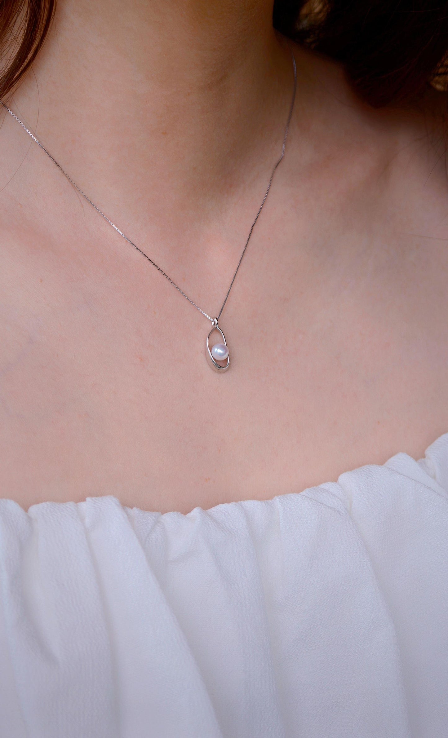 on-model-lace.pngCyrene Loop Pearl Necklace on neck with lace neckline — minimalist silver pendant with freshwater pearl detail