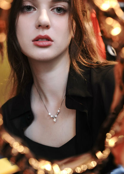 Female model wearing a minimalist 925 sterling silver pearl necklace from Cyrene.