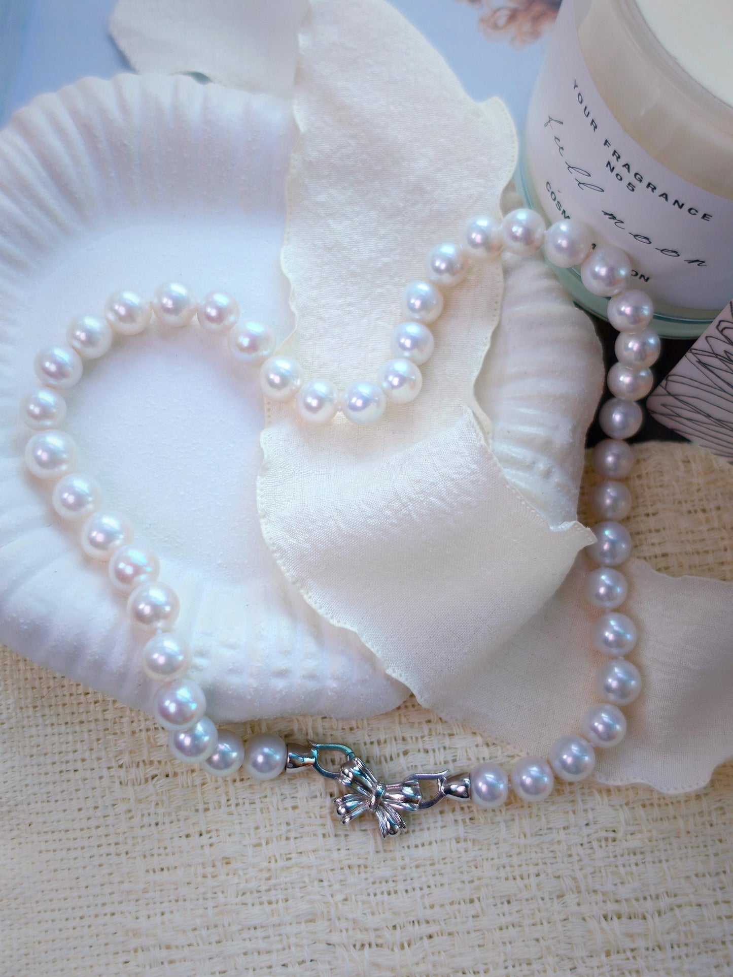 Cyrene by Elsie 9mm mirror-luster freshwater pearl necklace coiled with its sterling silver bow clasp