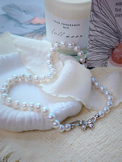 9mm freshwater pearl necklace by Cyrene by Elsie displayed beside a candle and shell