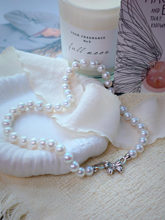9mm freshwater pearl necklace by Cyrene by Elsie displayed beside a candle and shell
