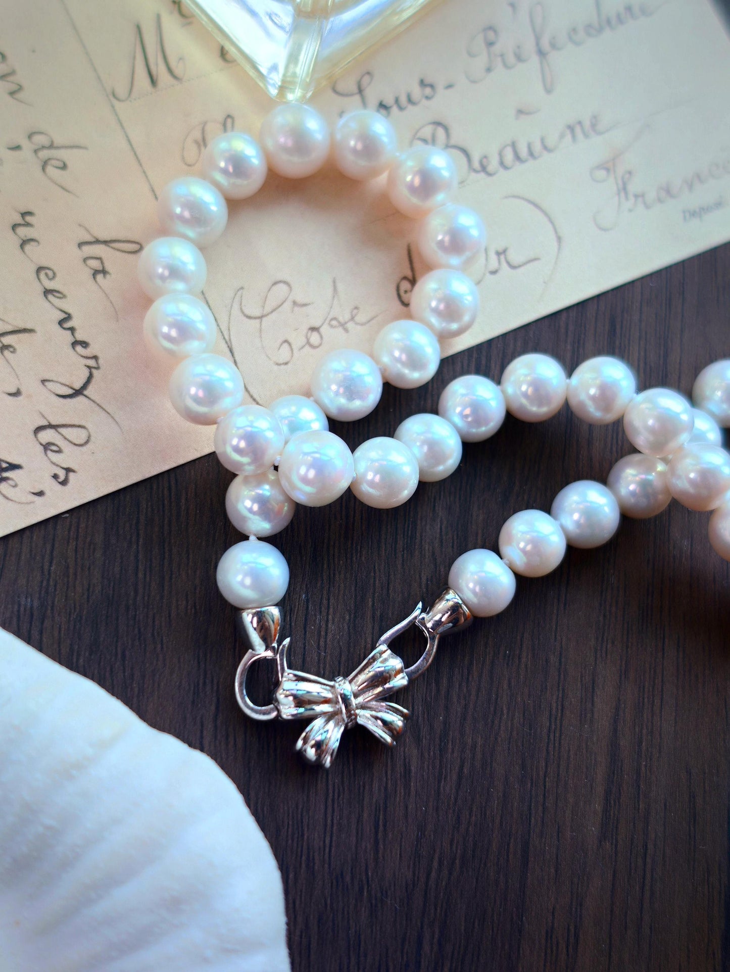 Close-up of the sterling silver bow clasp on Cyrene by Elsie's 9mm freshwater pearl necklace
