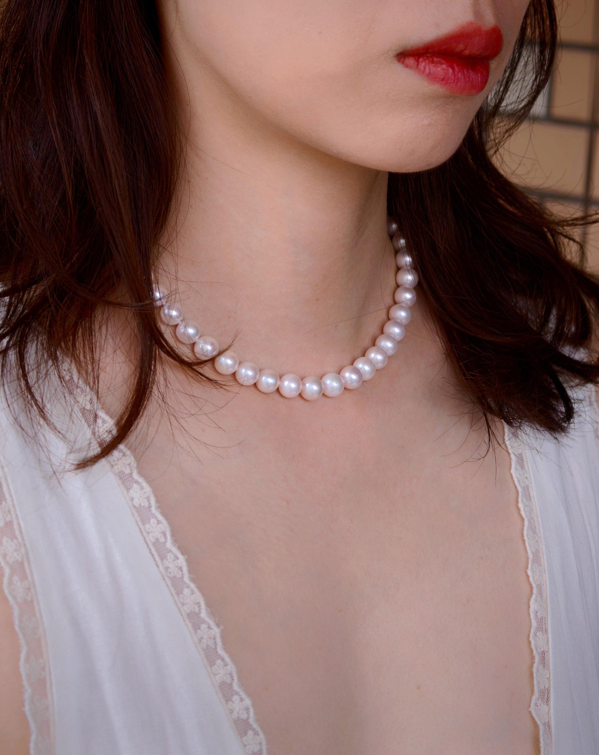 Model wearing Cyrene by Elsie's 9mm freshwater pearl necklace as a choker, clasp turned to the back