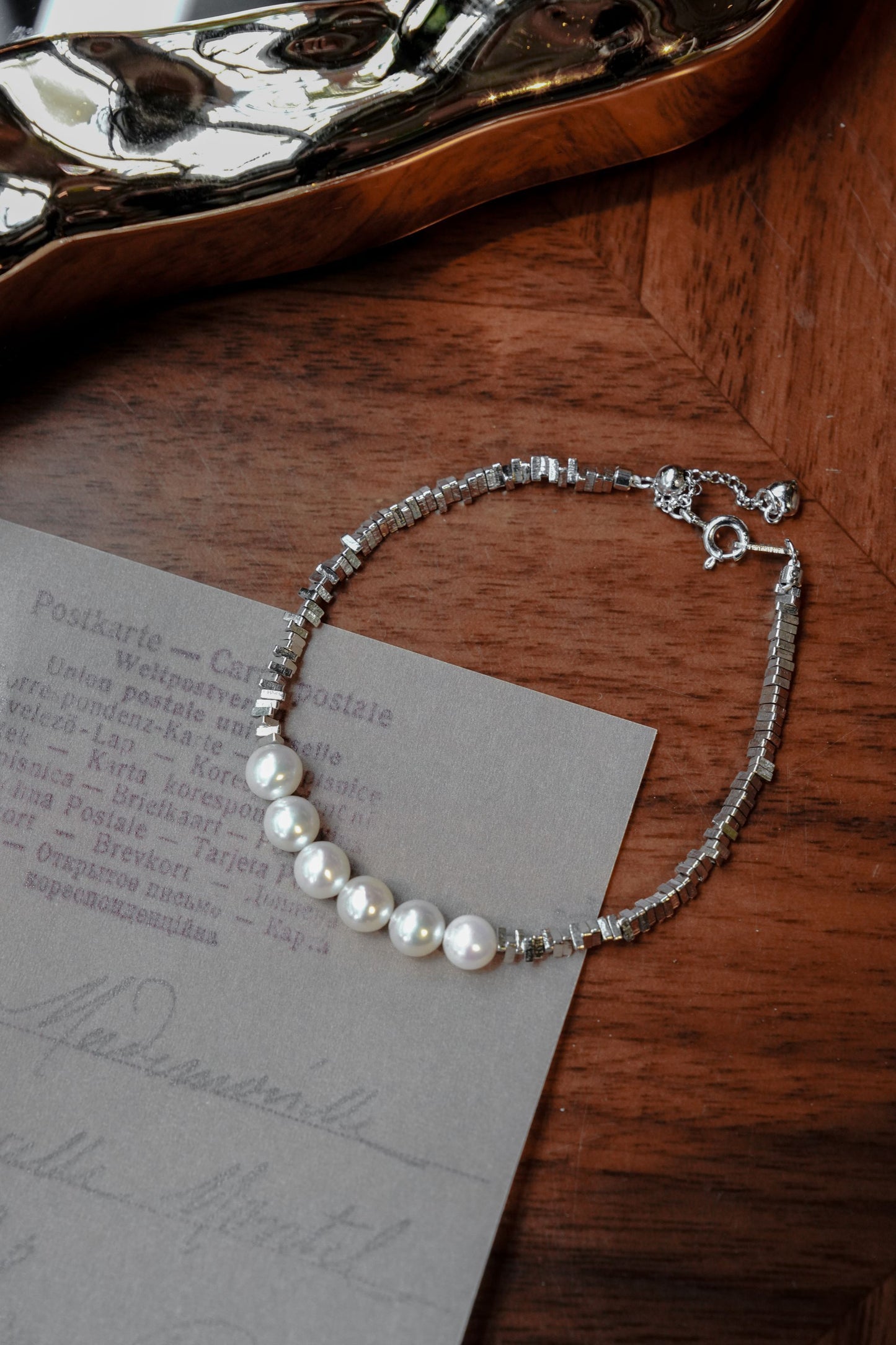 Close-up of a modern unisex bracelet by Cyrene, featuring round freshwater pearls and sharp crushed 925 silver.