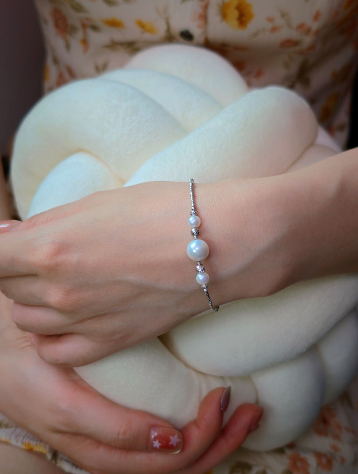 Model wearing Cyrene Moirae Pearl Bar Bracelet, three aurora freshwater pearls on textured silver chain