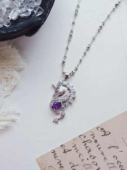 Cyrene Moonglass Unicorn 925 silver pendant necklace with natural amethyst and CZ stones, flat lay on white surface