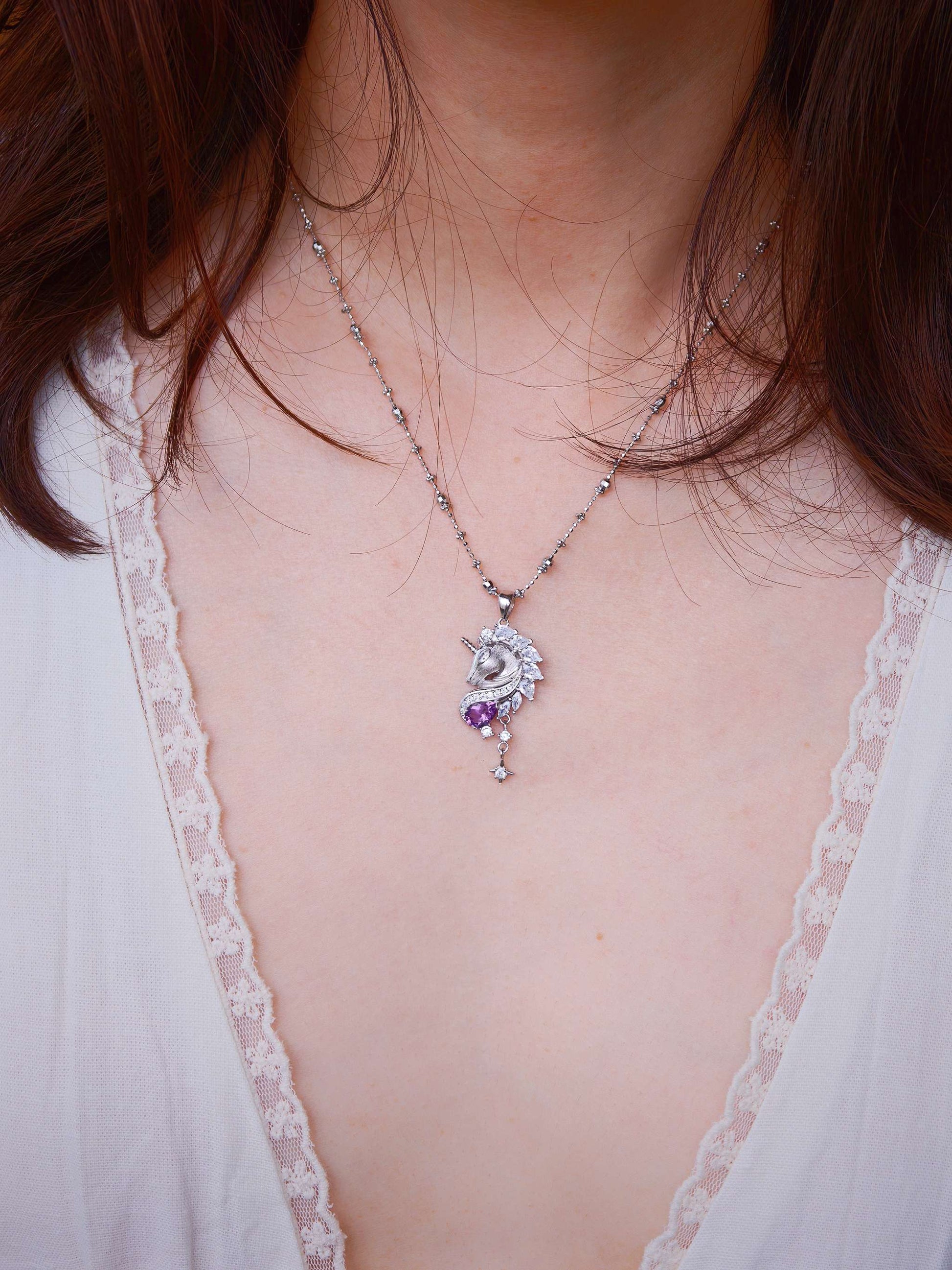 Close-up of Cyrene Moonglass Unicorn necklace on model, natural amethyst and silver unicorn pendant on satellite chain
