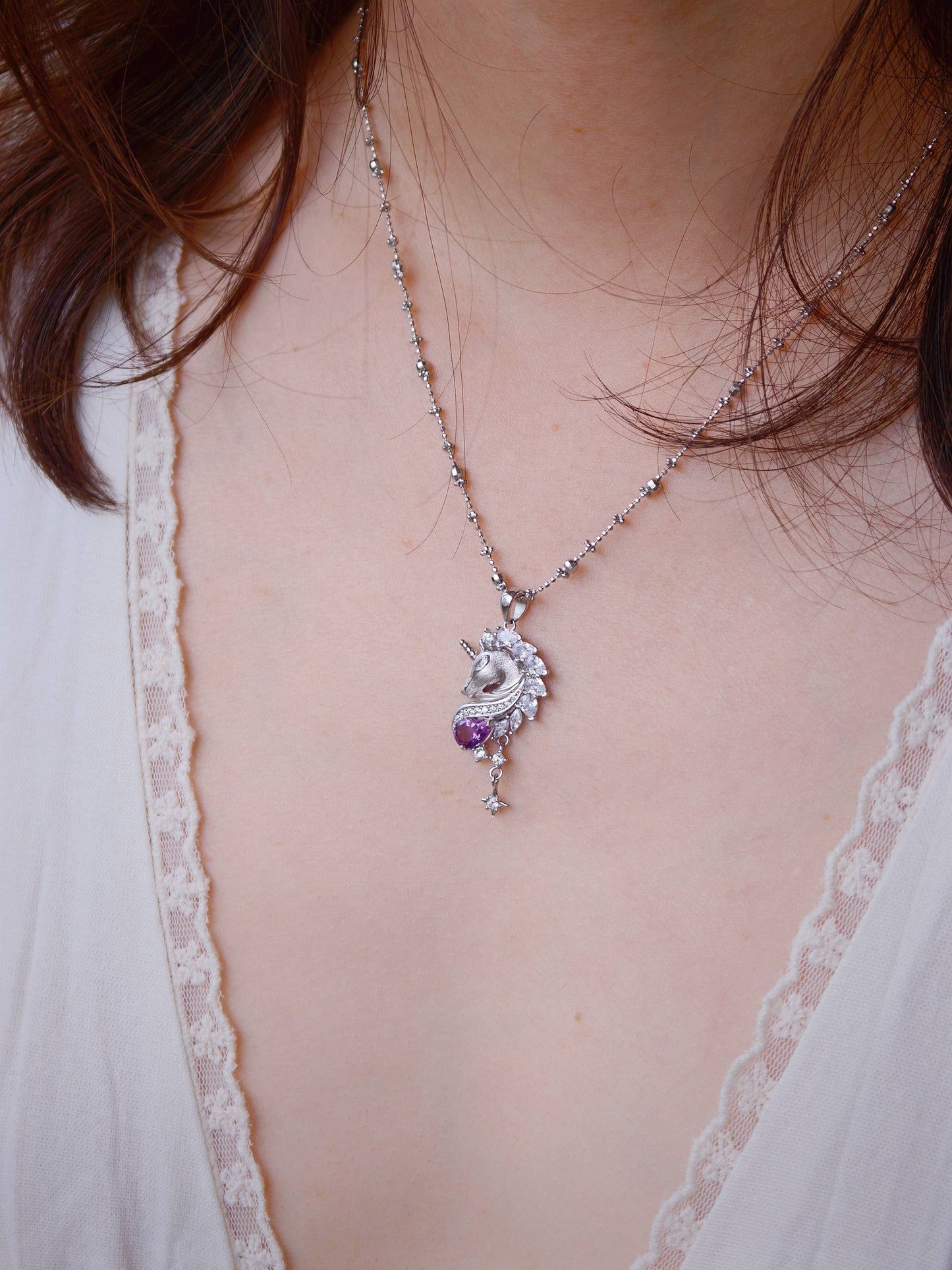 Model wearing Cyrene Moonglass Unicorn silver necklace, pendant sitting at chest, 44cm adjustable chain