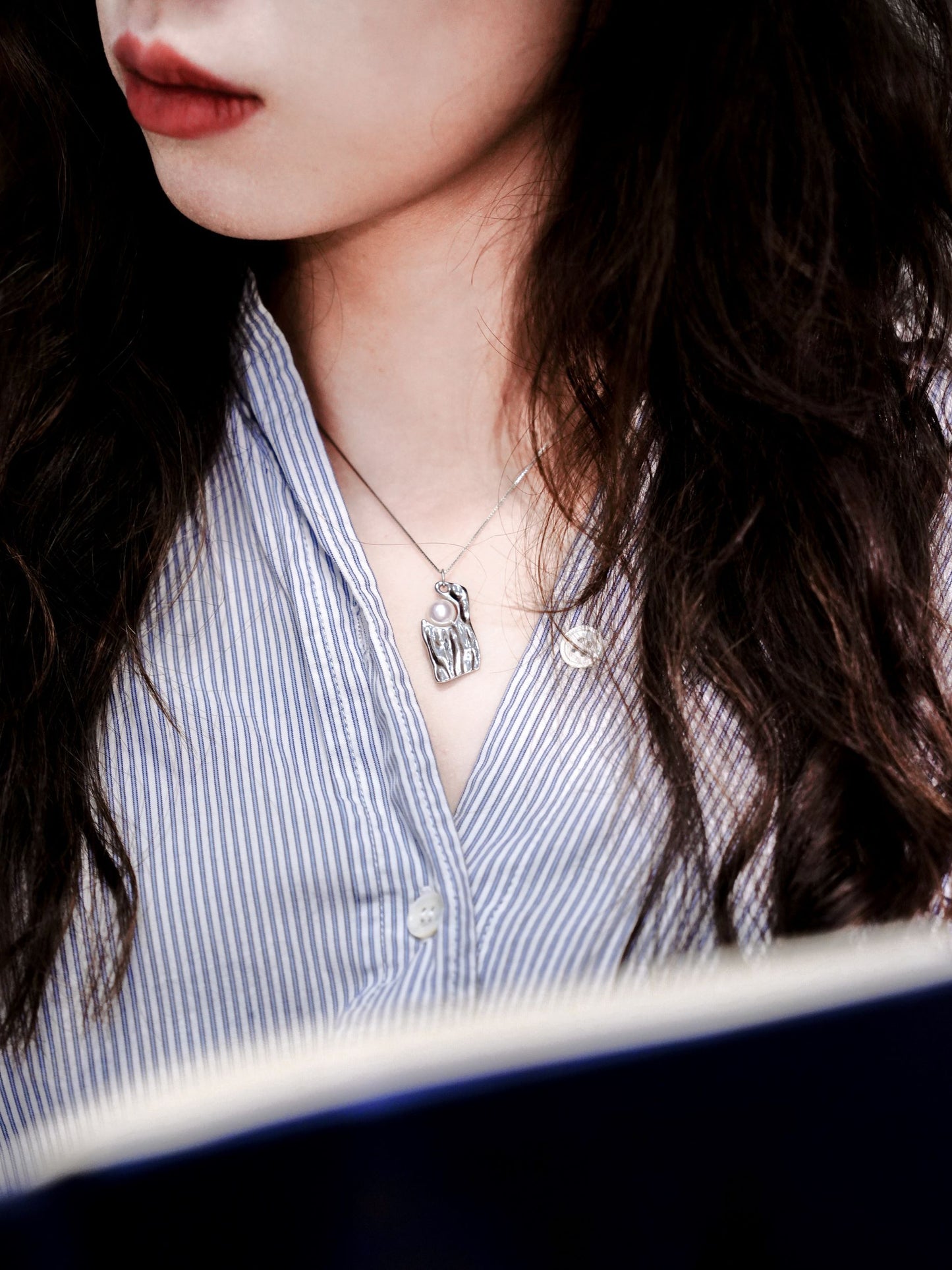 A sharp and professional boss lady look featuring Cyrene's silver wave pearl necklace layered perfectly over a striped shirt.