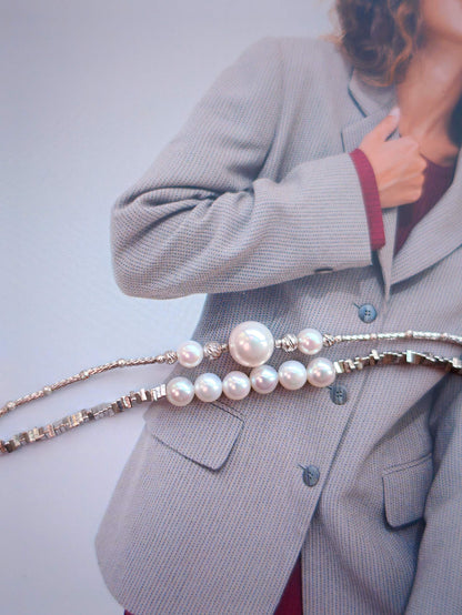 Cyrene pearl bracelets stacked on wrist over blazer, Relic Fragment and Moirae bracelet styling