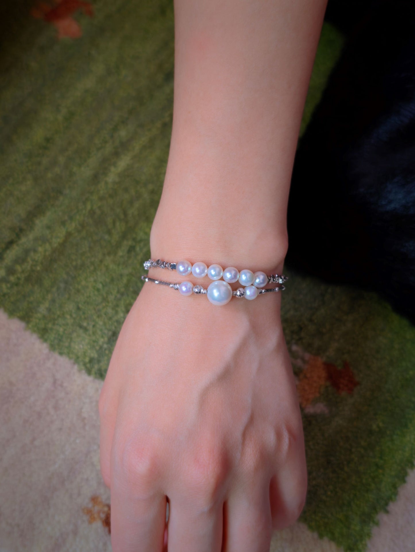 Cyrene Relic Fragment Pearl Bracelet stacked with Moirae bracelet on wrist, layered pearl jewelry