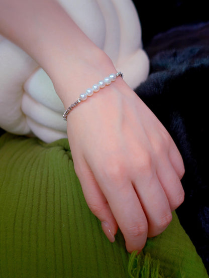 Cyrene Relic Fragment Pearl Bracelet close-up on wrist, aurora pearls with textured silver chain detail