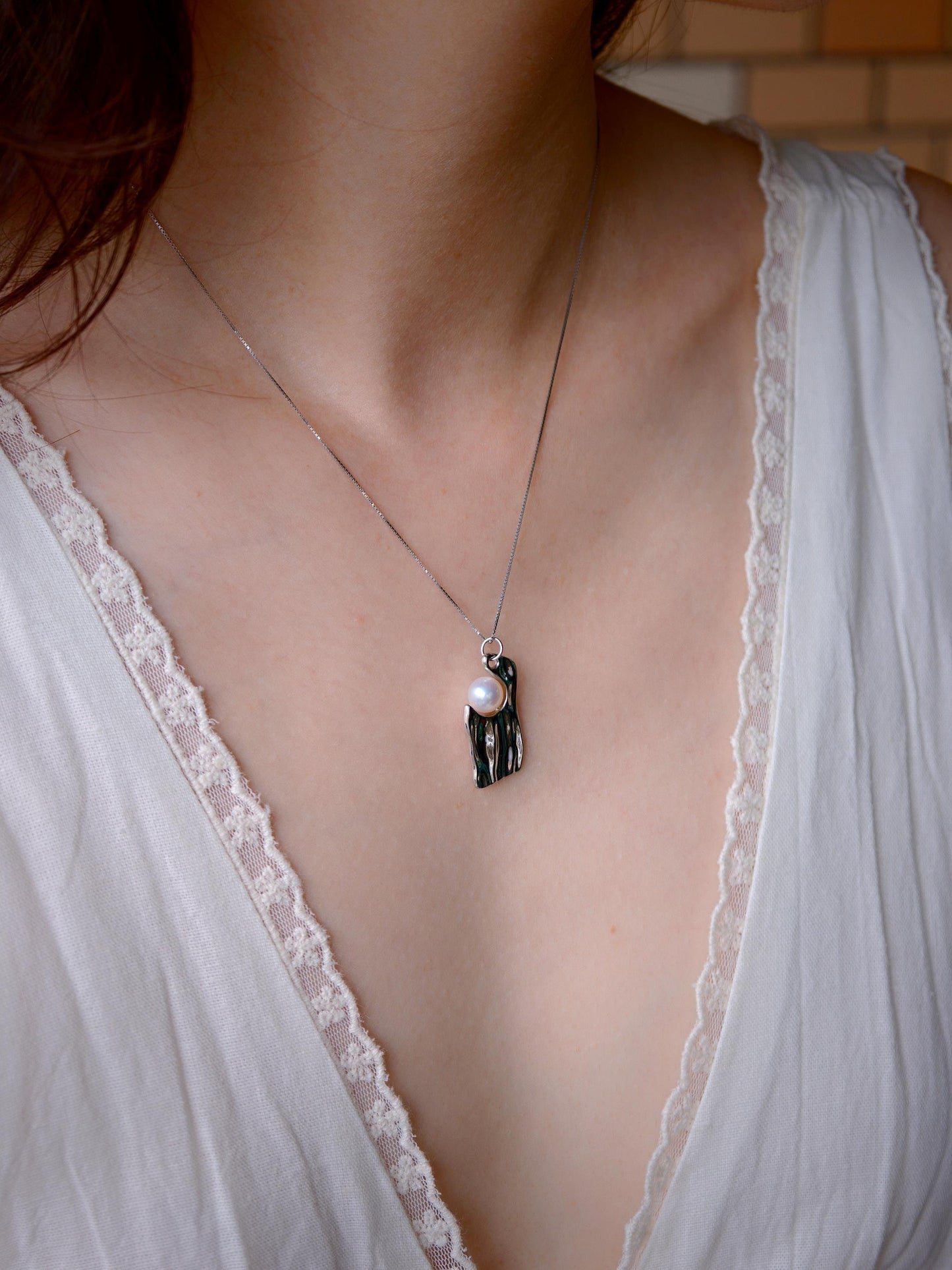 Model wearing Cyrene by Elsie's 925 silver and 7-8mm freshwater pearl pendant necklace in natural light