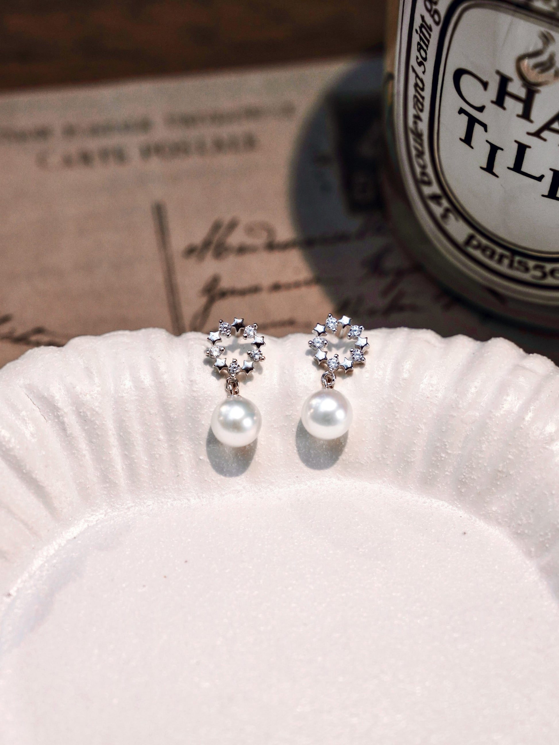 Romantic vintage aesthetic showcasing Cyrene's delicate crown pearl studs with a radiant freshwater pearl drop