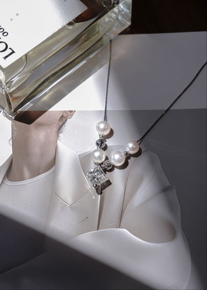 Close-up of a Cyrene round freshwater pearl and moissanite pendant necklace.