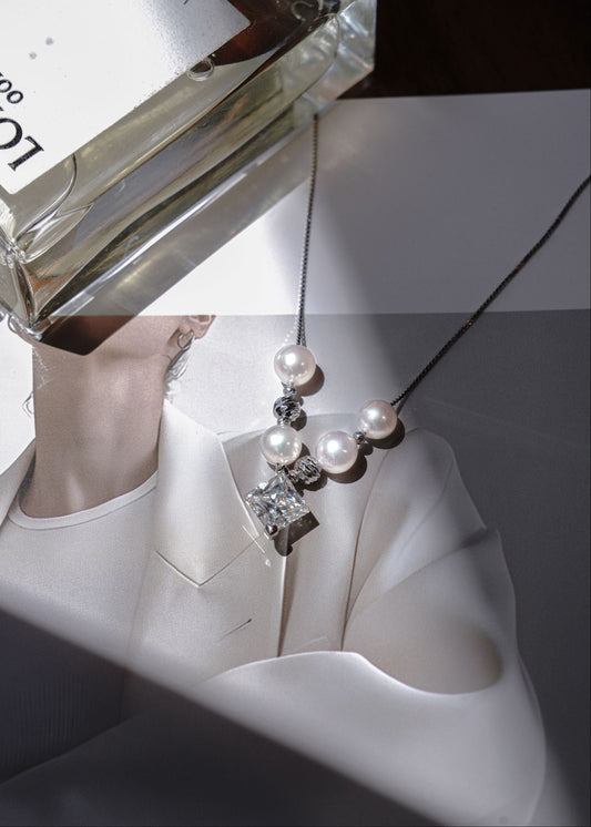 Close-up of a Cyrene round freshwater pearl and moissanite pendant necklace.
