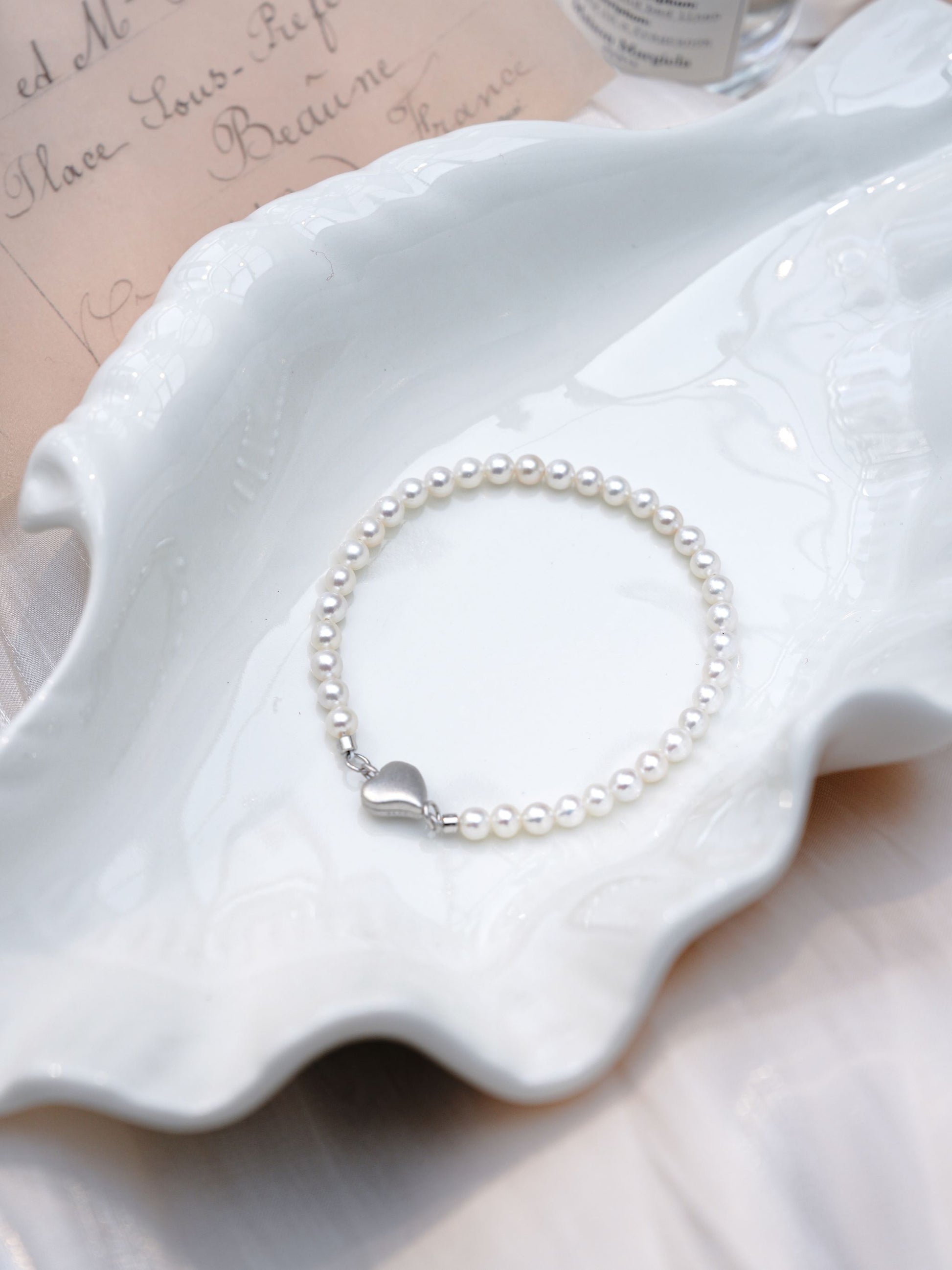 Close-up of the secure interlocking 925 silver heart magnetic clasp on a Cyrene mini freshwater pearl bracelet.