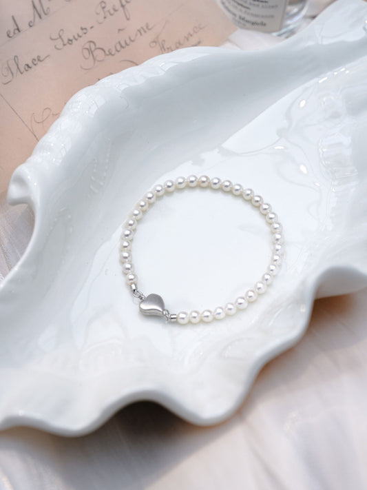 Close-up of the secure interlocking 925 silver heart magnetic clasp on a Cyrene mini freshwater pearl bracelet.