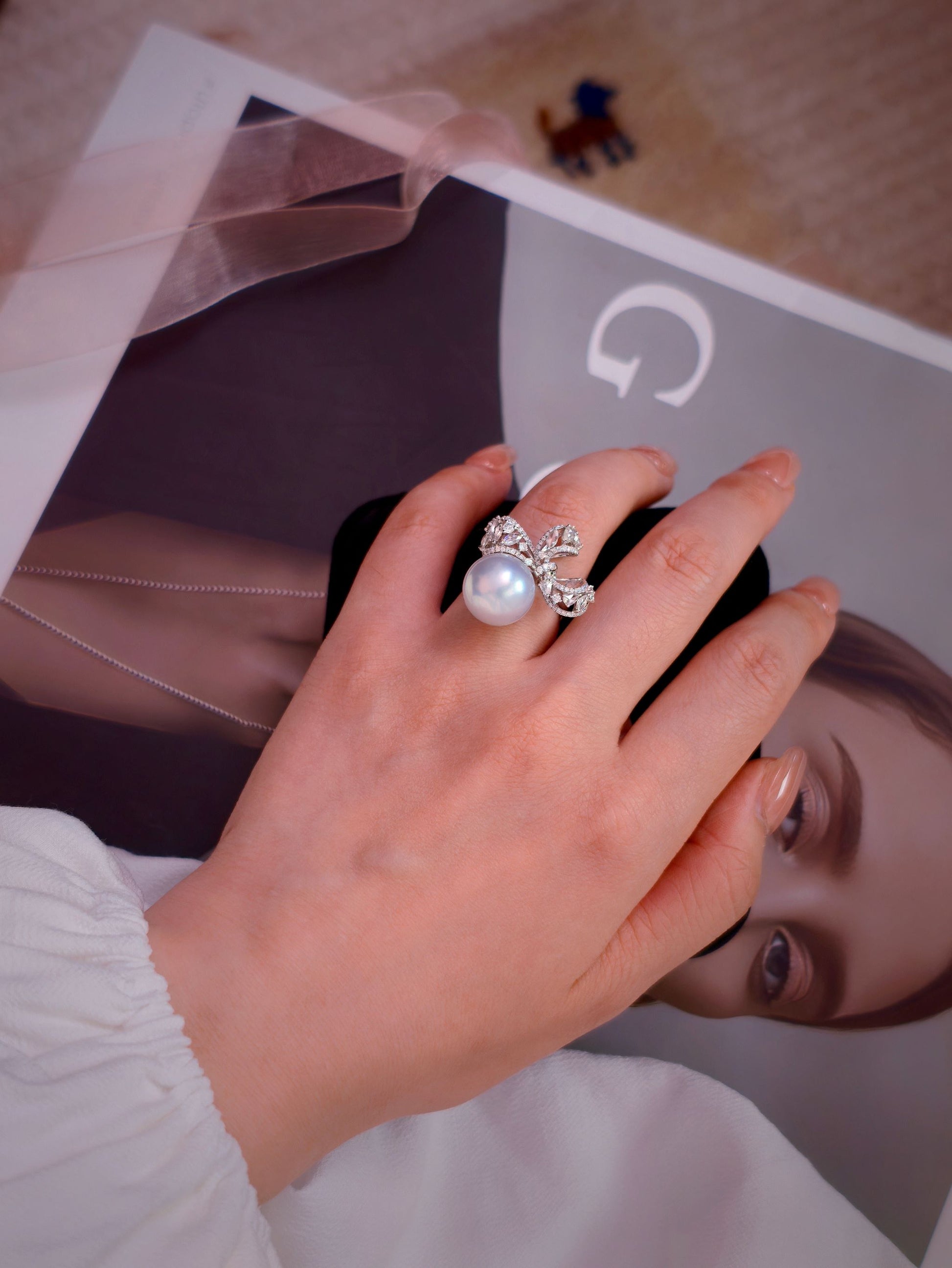 Cyrene Solitaire Bow Pearl Ring styled with ribbon on editorial background — 18K white gold diamond bow ring with rare silver-blue South Sea pearl