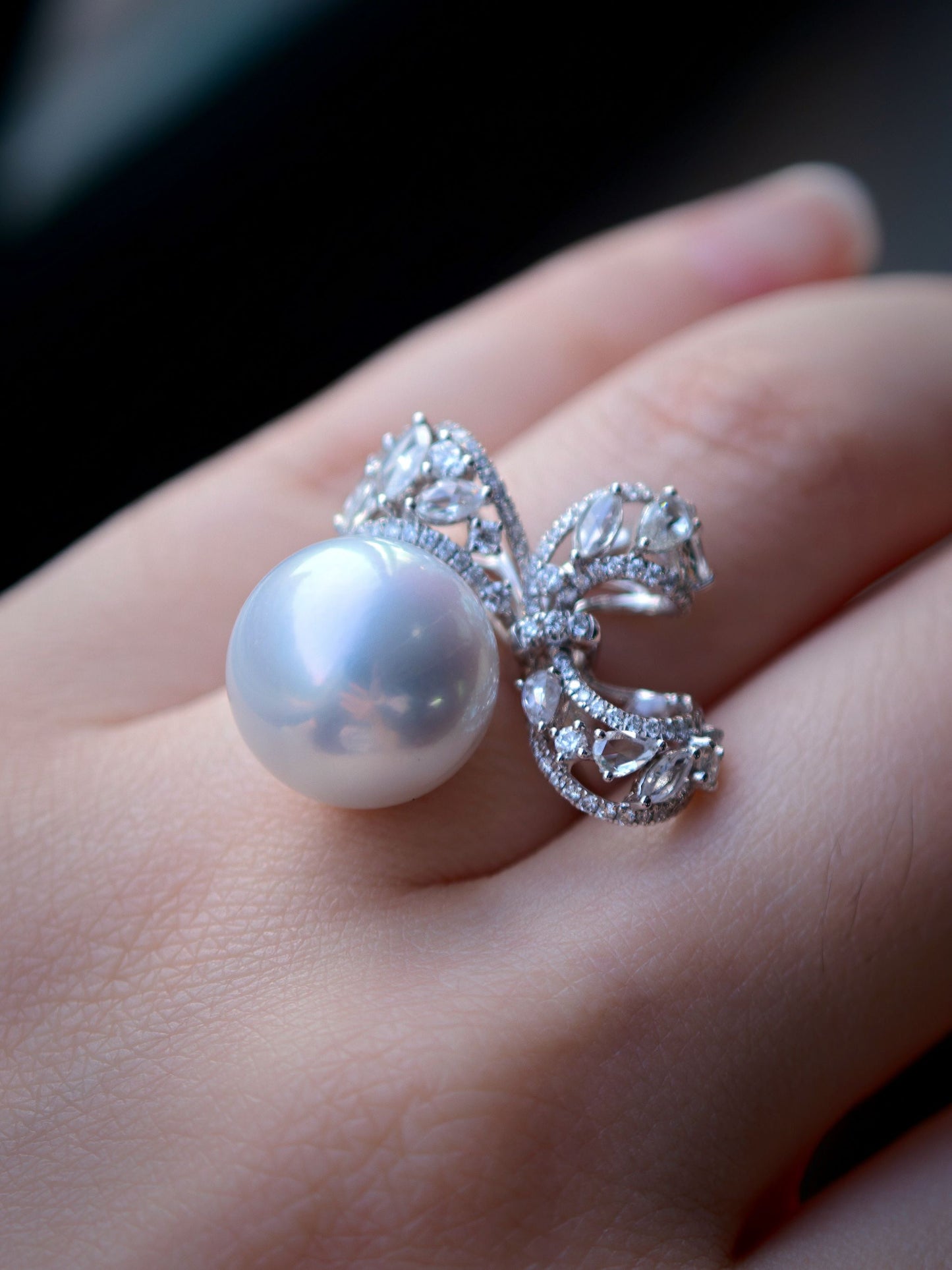 Cyrene Solitaire Bow Pearl Ring close-up on finger — flawless round South Sea pearl with diamond bow detail