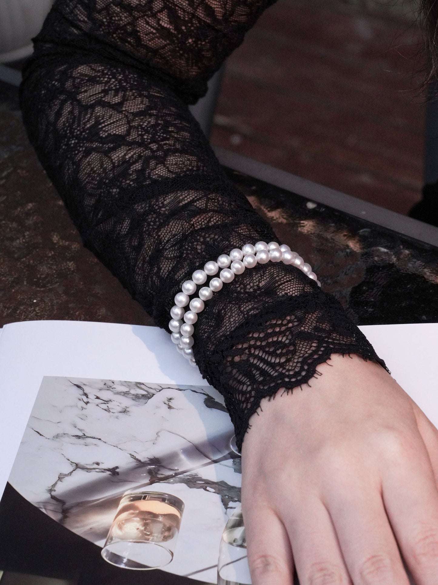 Sophisticated double-layered pearl cuff bracelet adding brilliant contrast to a dark romantic lace outfit