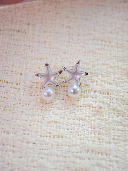 Cyrene Starshore Pearl Earrings — starfish stud earrings with mother-of-pearl inlay and round freshwater pearl, close-up flatlay