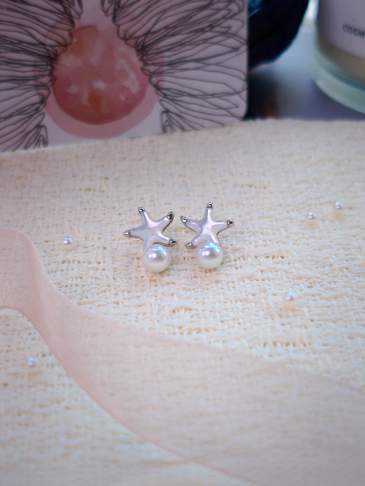 Cyrene Starshore Pearl Earrings — 925 sterling silver and mother-of-pearl starfish studs with freshwater pearl drops, flatlay