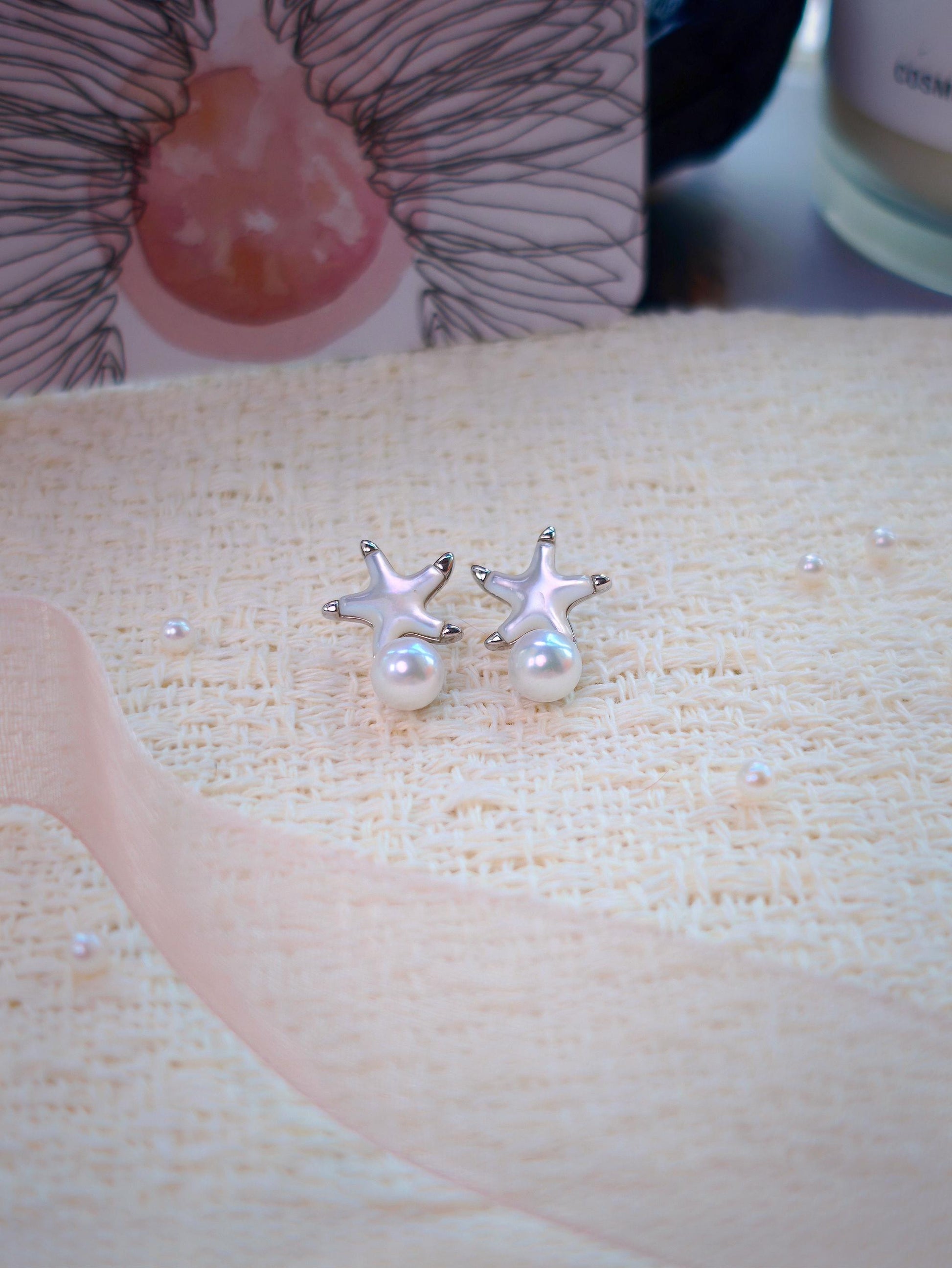 Cyrene Starshore Pearl Earrings — 925 sterling silver and mother-of-pearl starfish studs with freshwater pearl drops, flatlay
